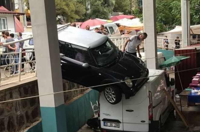 İzmir`de hakimiyetini kaybeden araç pazar yerinin üzerinde asılı kaldı